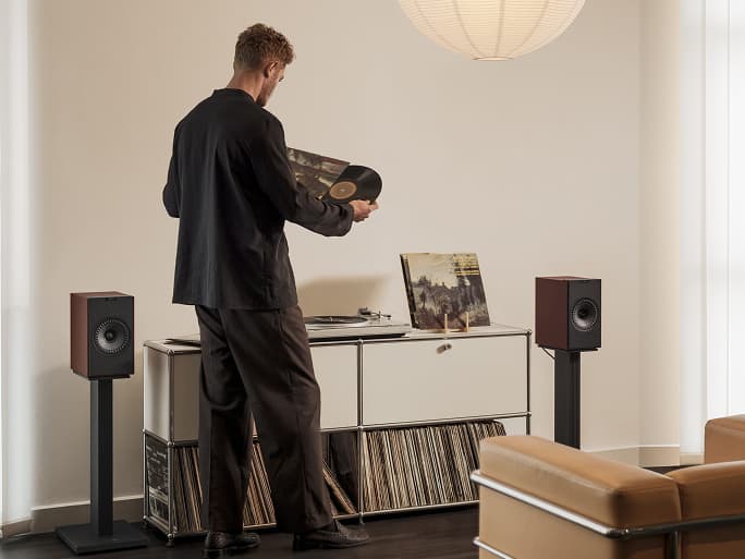 人们在客厅里用 Coda W 扬声器听黑胶唱片。