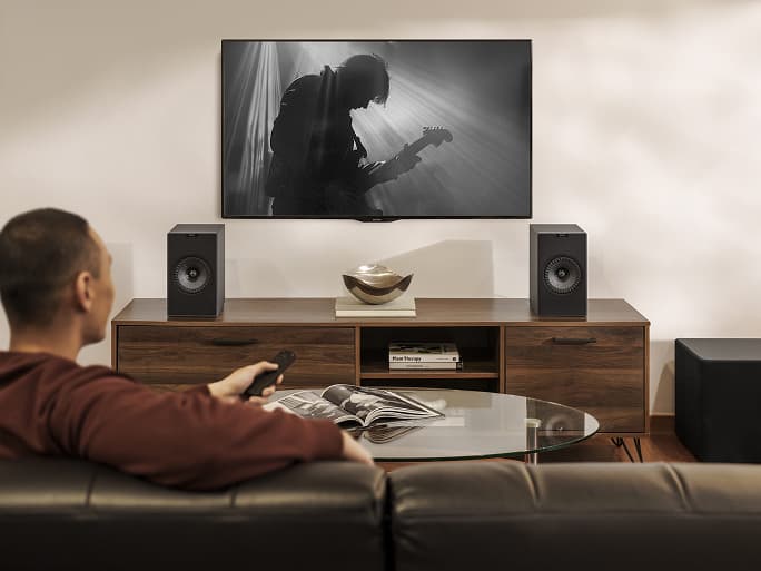 人们在客厅里用 Coda W 扬声器听音乐。