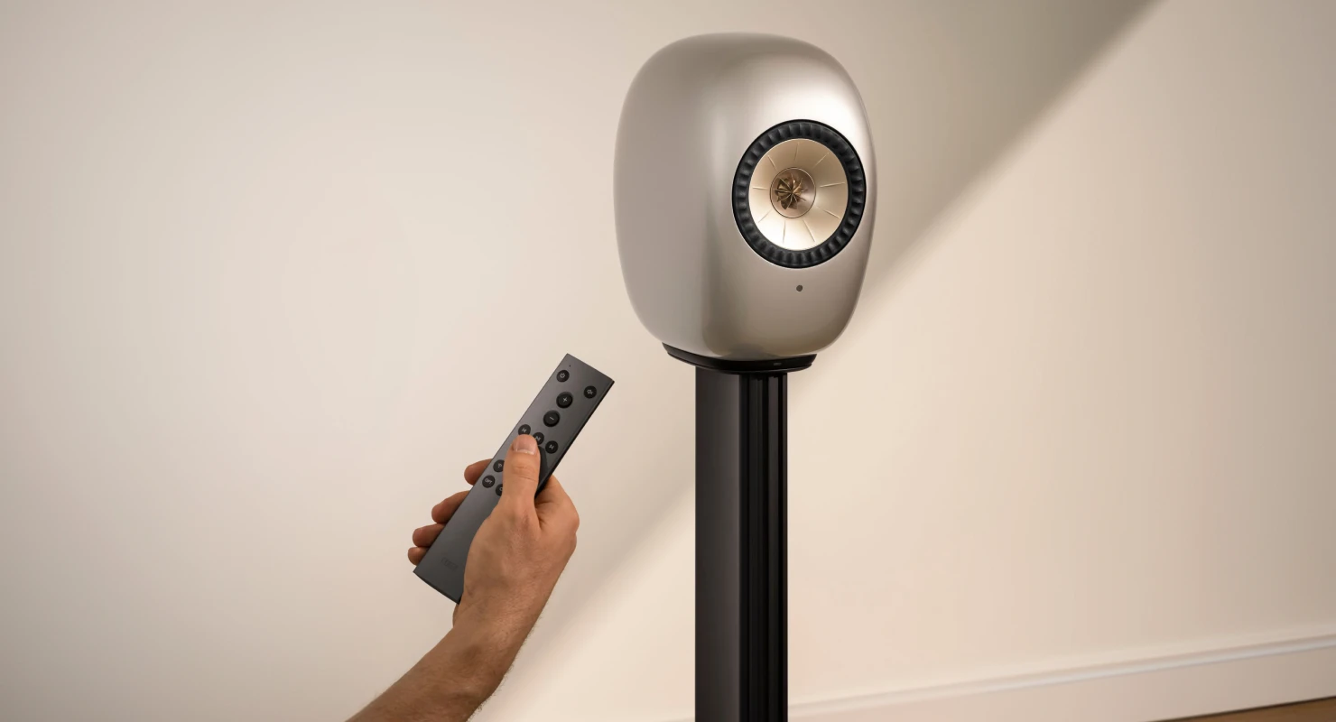 Blue Muo Bluetooth speaker hanging from carrying strap in bathroom is being controlled via phone.