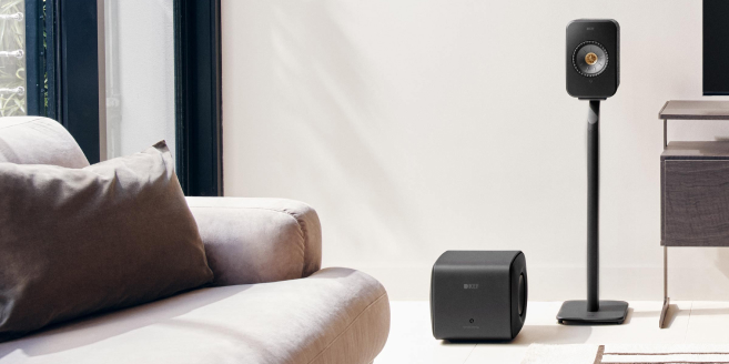 A cozy living room with a KC62 subwoofer and LSX II Wireless Speaker.