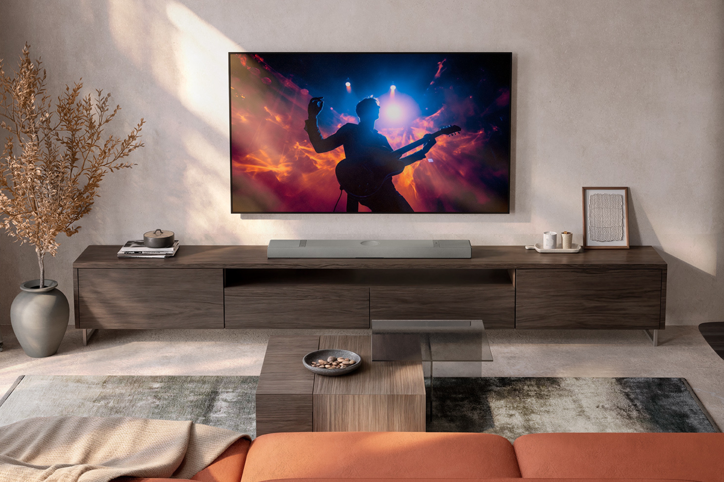 KEF Soundbar unter einem wandmontierten Fernseher in einem modernen Wohnzimmer für ein immersives Heimkino-Klangerlebnis