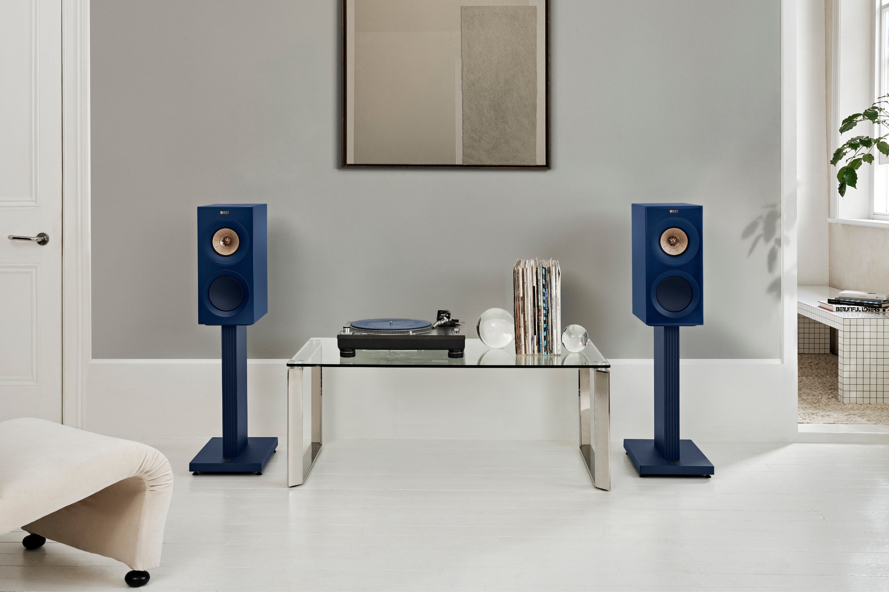 KEF blaue Regallautsprecher auf Ständern kombiniert mit einem Plattenspieler in einem stilvollen HiFi-Setup