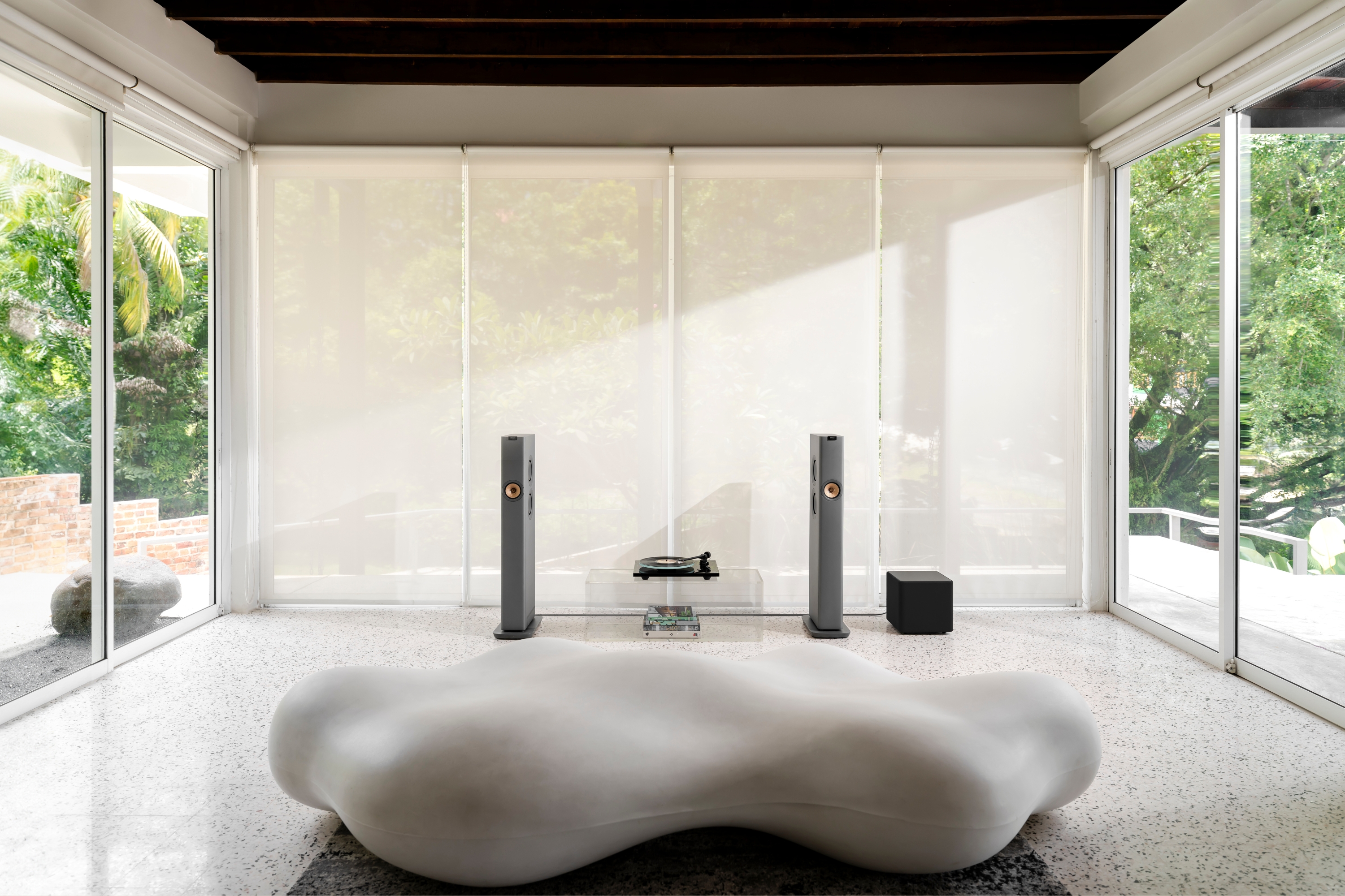 LS60 Wireless geplaatst in een woonkamer naast de Kube 12 MIE subwoofer