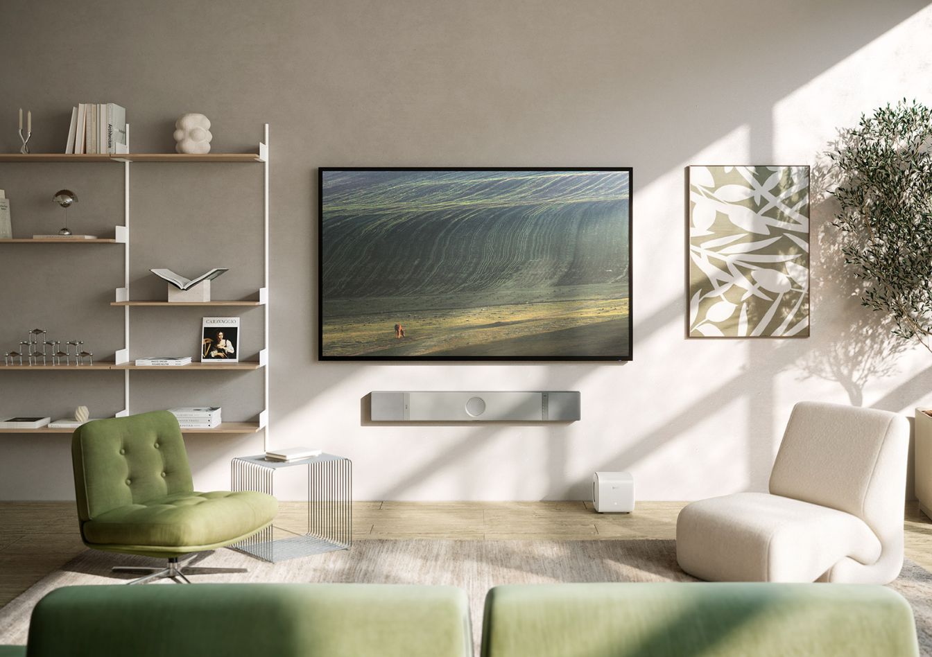 Moderne woonkamer met een wandgemonteerde televisie, minimalistische planken, een groene fauteuil en een neutraal interieur in natuurlijk licht.