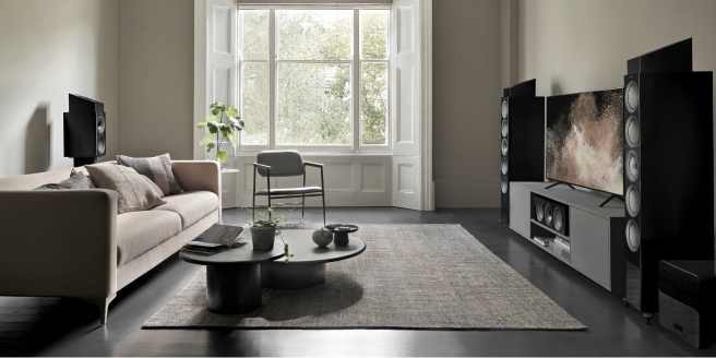 KEF luidsprekers en subwoofer systeem in een stijlvolle woonkamer met homecinema-opstelling