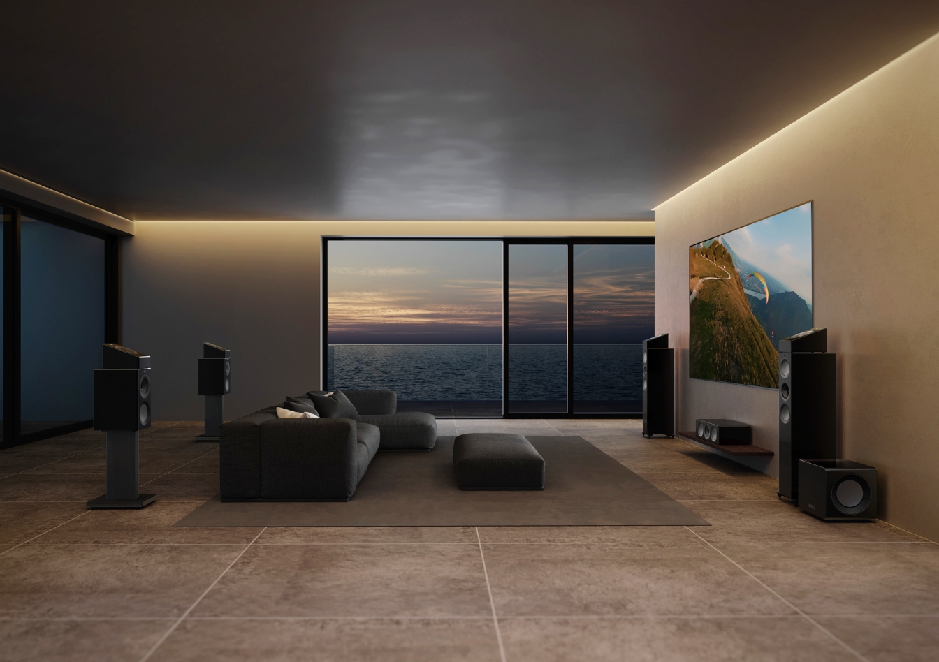 Modern home cinema living room with Dolby Atmos surround sound speakers and large TV overlooking ocean view