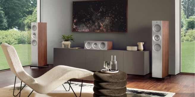 Salon contemporain avec des enceintes sur pied positionnées pour un son optimal, doté de meubles modernes et de grandes fenêtres.