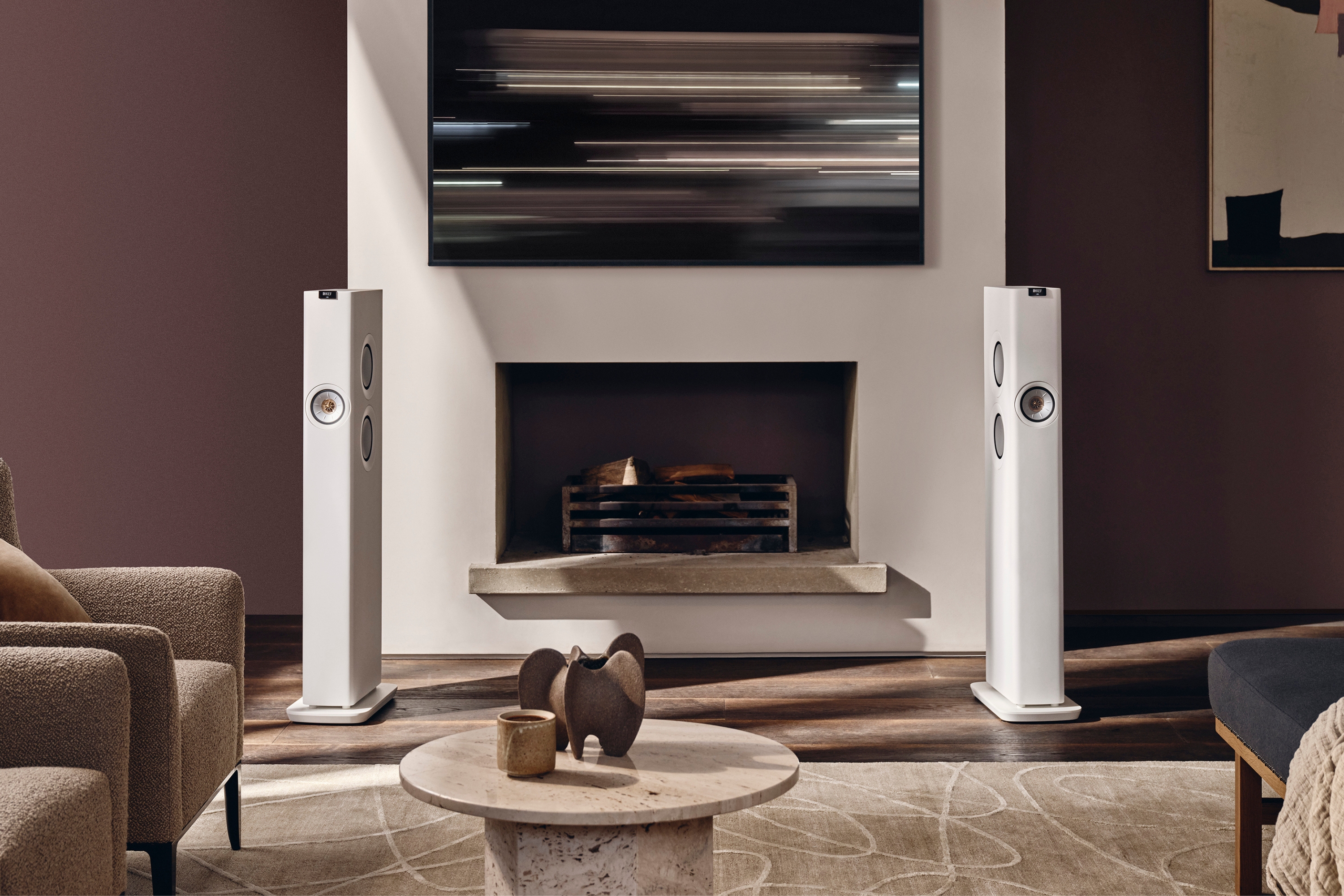 A pair of LS60 Wireless speakers placed in a living room between a fireplace
