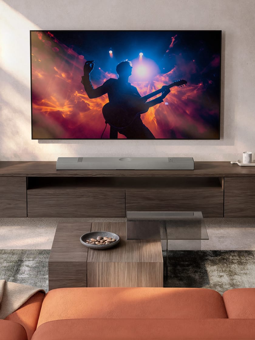 Salon avec télévision et barre de son XIO couleur argent posée sur un buffet.