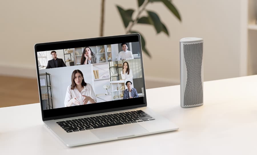 Enceinte Bluetooth Muo argentée utilisée pour une vidéoconférence sur un ordinateur portable.