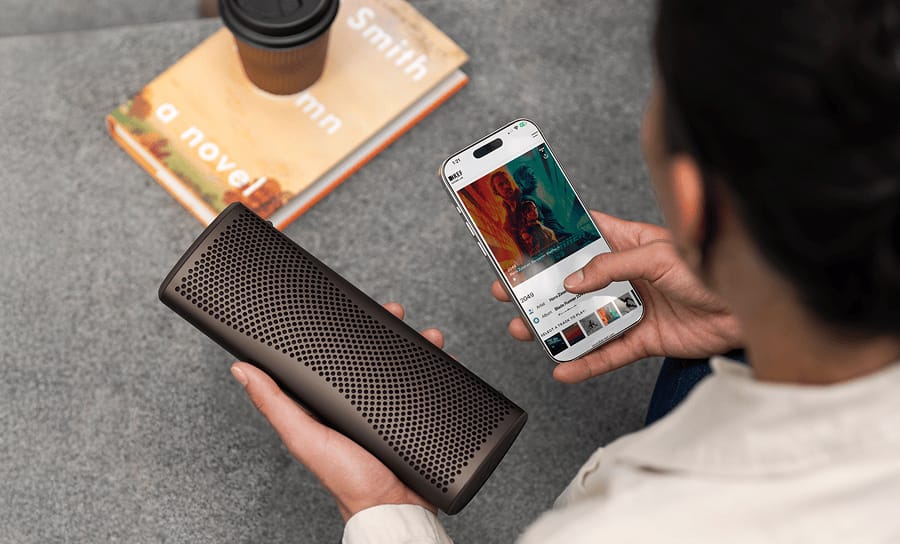 Enceinte Bluetooth Muo marron contrôlée depuis l’application KEF Connect.